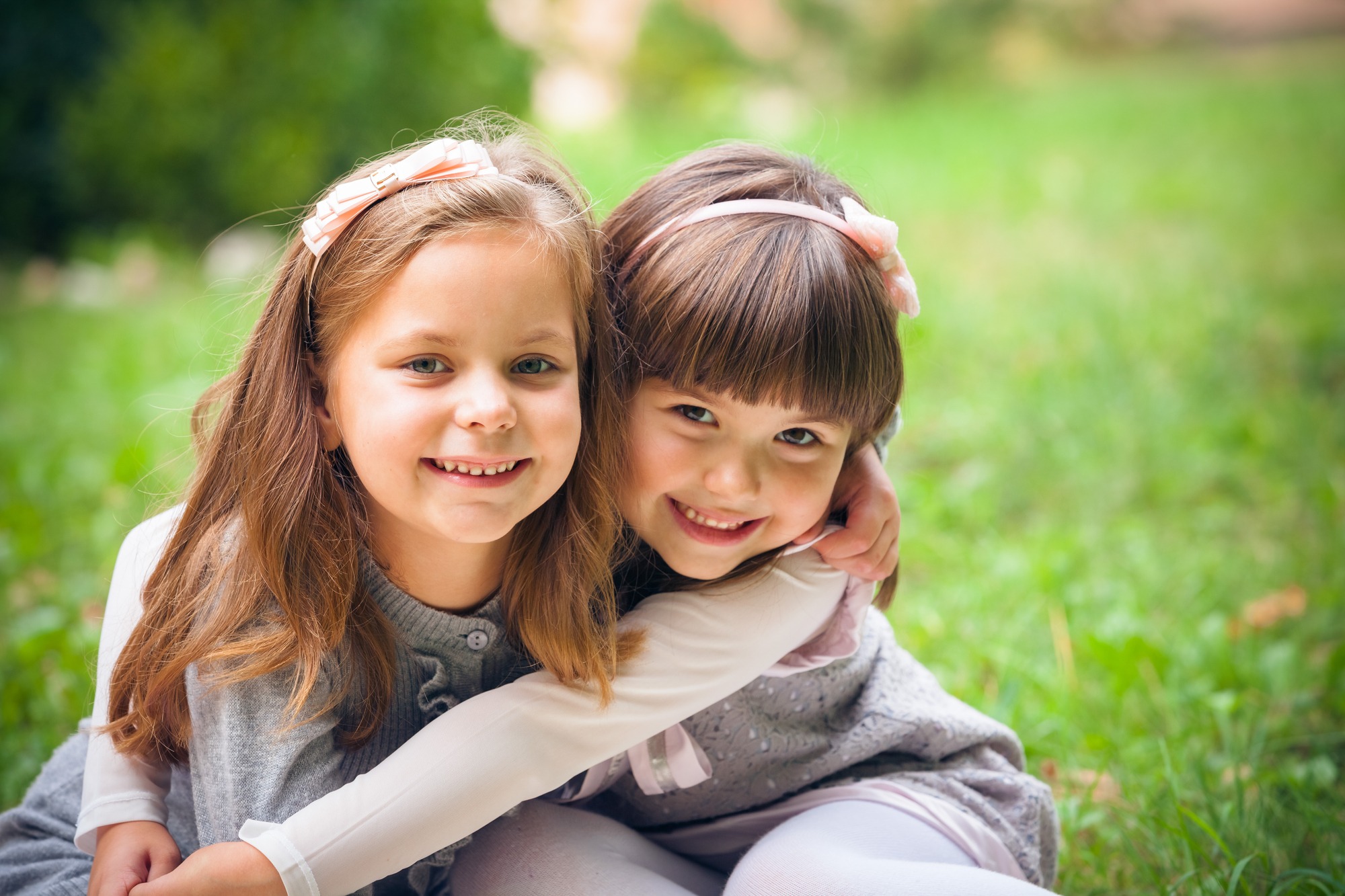 Happy little girlfriends in park